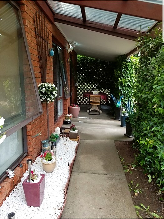 Maintained lawn and trimmed greenery along a garden walkway