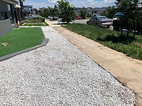 Freshly mown lawn and neatly edged garden beds with white pebbles at a Throsby home
